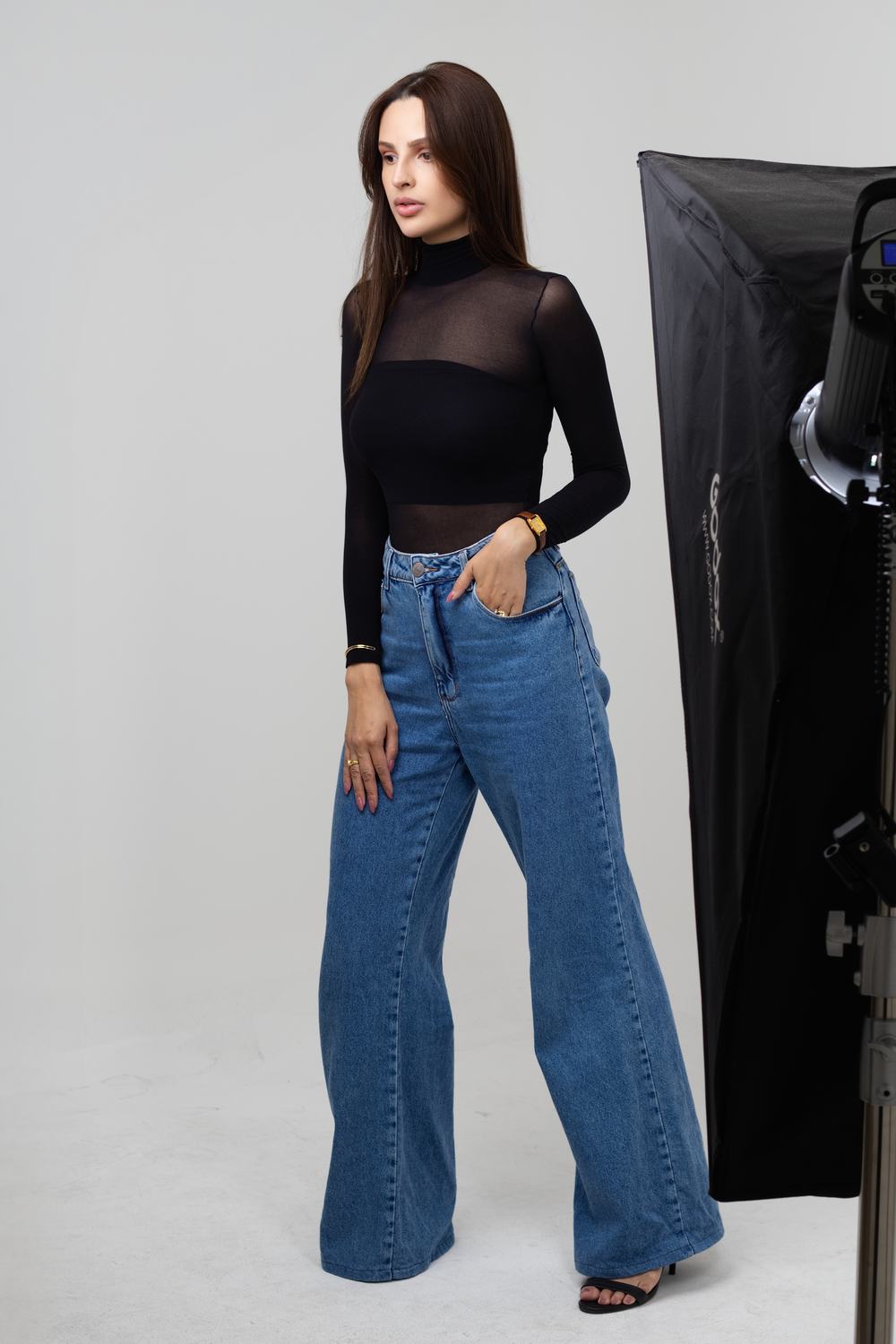 Bastidores de ensaio nos est&uacute;dios da Aliar, com softbox montado ao lado da modelo