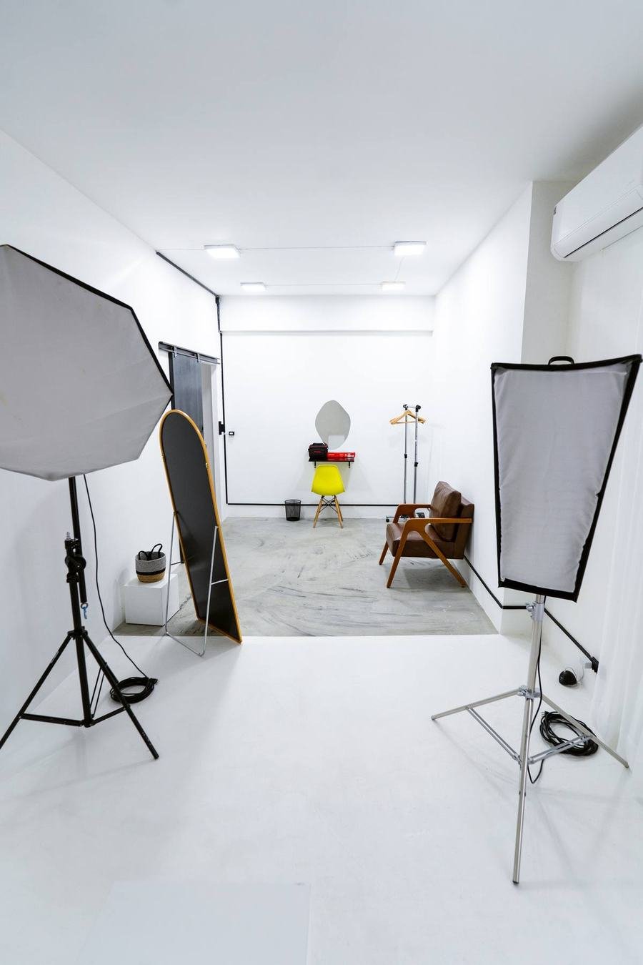 Estúdio da Aliar Marketing com dois softboxes, poltrona e fundo branco, em Goiânia