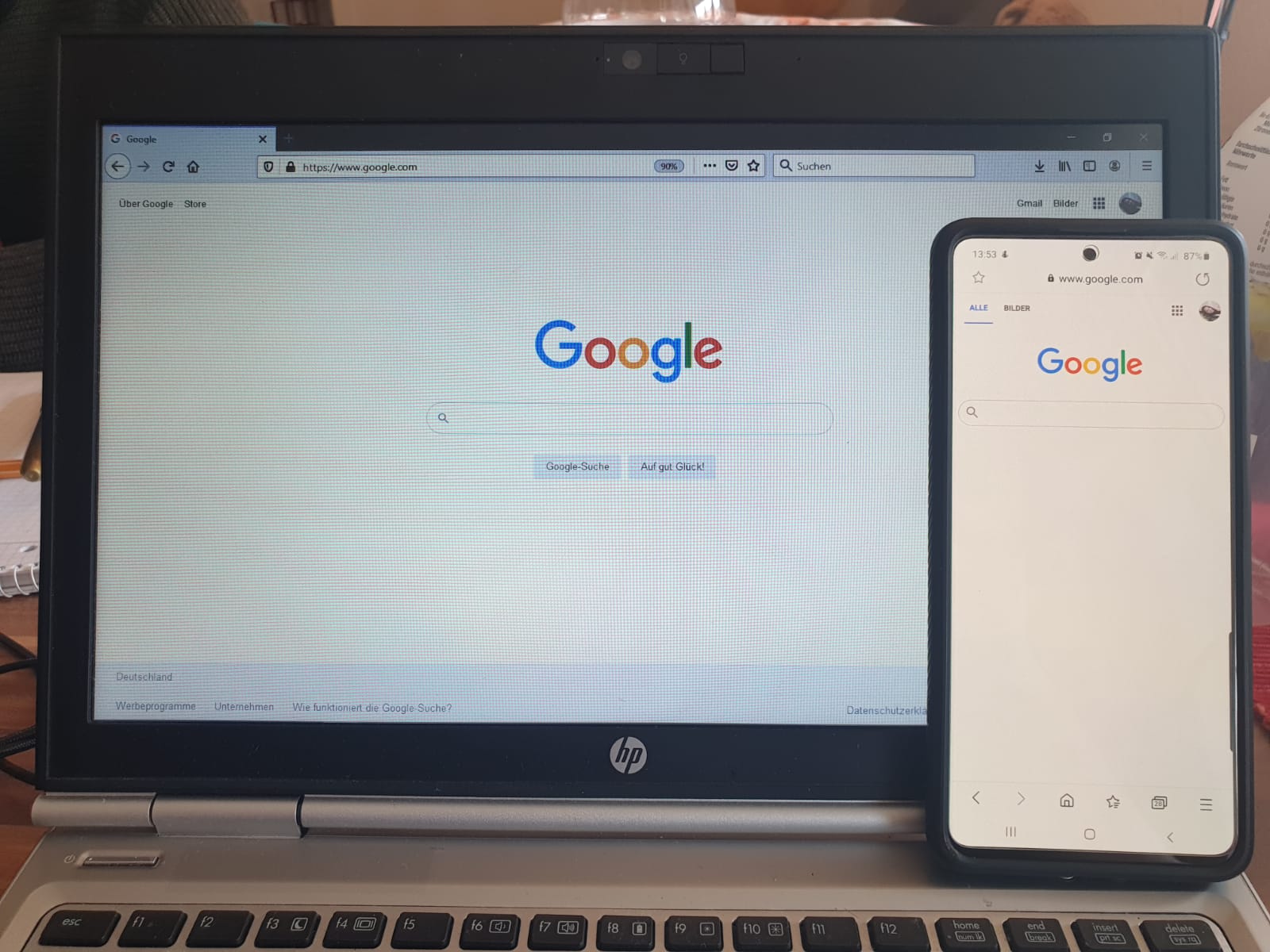 Página inicial do Google aberta em um notebook e em um celular lado a lado