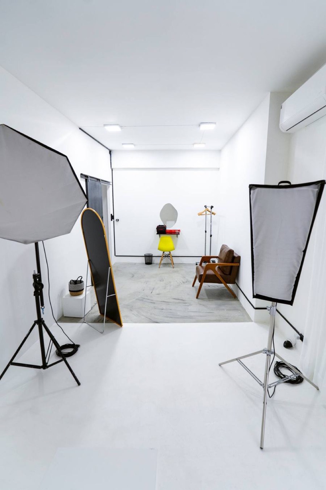Dois softboxes de iluminação montados num estúdio branco vazio, prontos para uma gravação